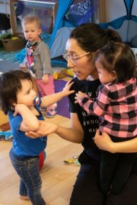 Une enseignante intervient pour empêcher un enfant fâché de frapper un autre enfant.