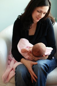 Parent gazing at baby's face on their lap.